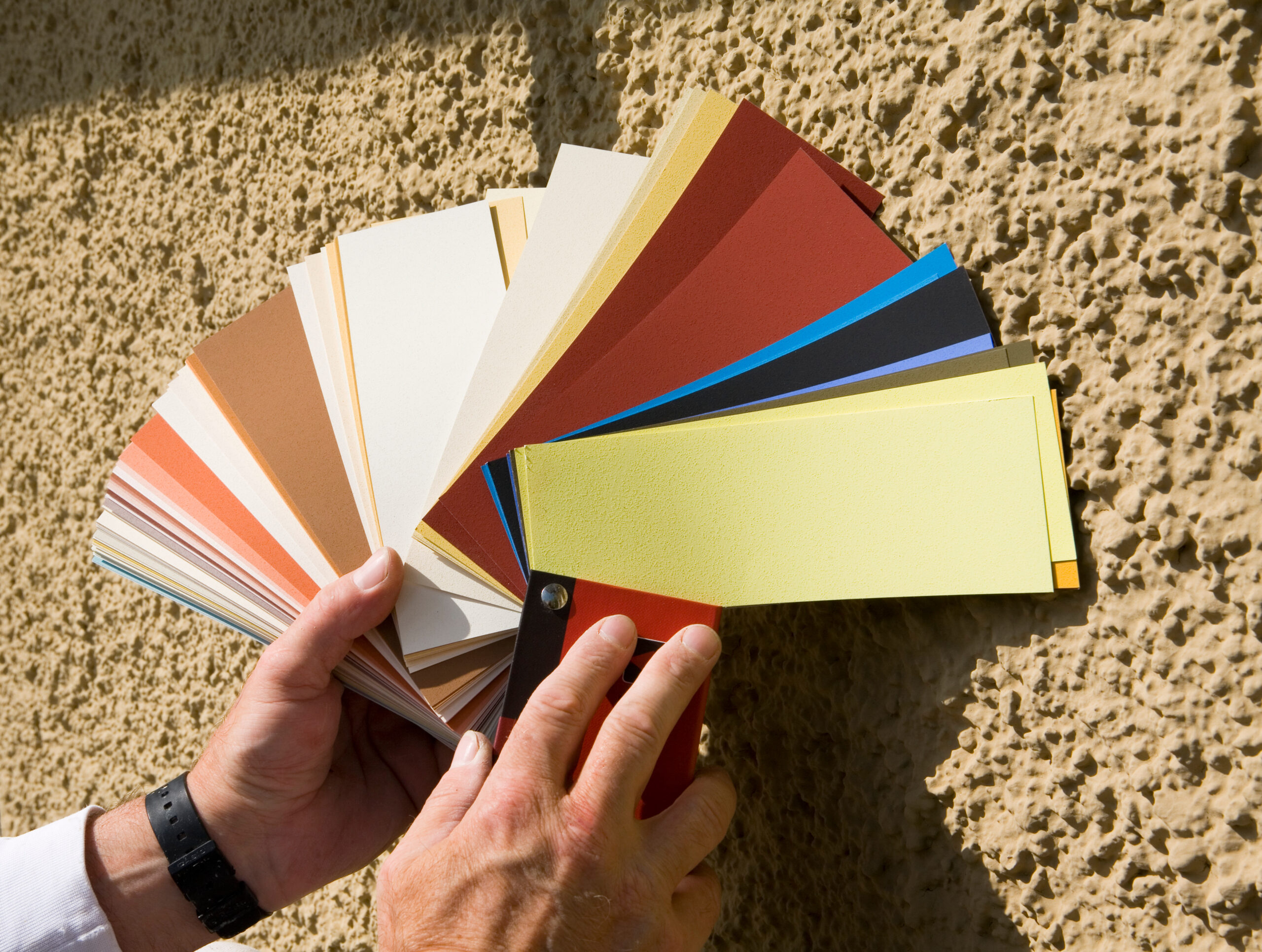 Farbfächer vor einer Hauswand